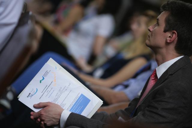 a man wearing a suit and tie reading a book