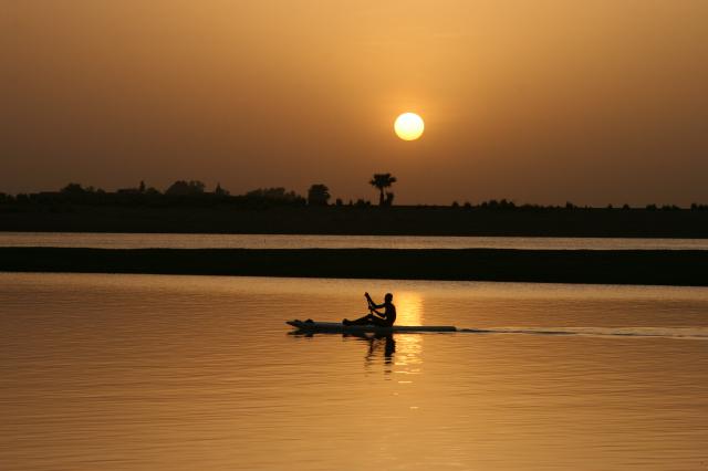 A small boat on a river during sunset
