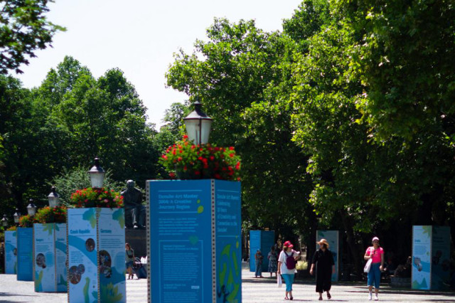Panels on a wide pedestrian street showcasiung art works