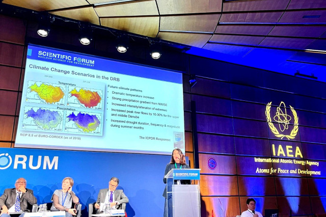 Woman stands at a podium in a conference room 