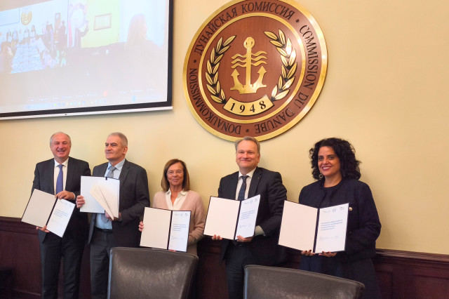 Five representatives hold up copies of the Joint Statement 2.0 document.