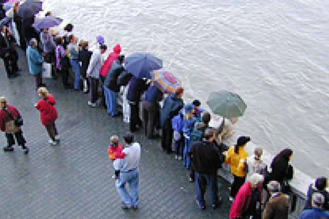 A crowd of people over looking a body of water 