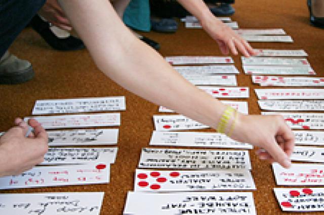 hands of people sorting sheets of paper
