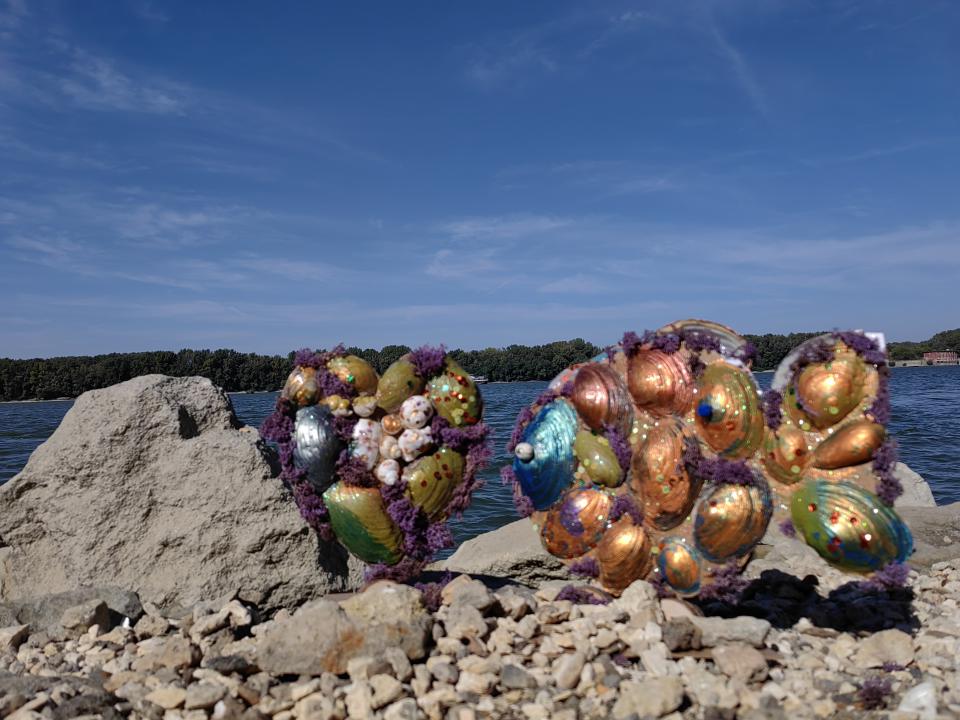 Winning Art Work from Bulgaria Shells painted in gold, green and blue, assembled in two sets and displayed on the shore of the Danube